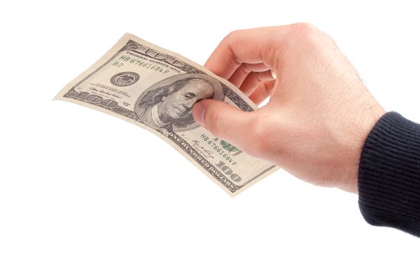 Hand holding 100 dollar bill.