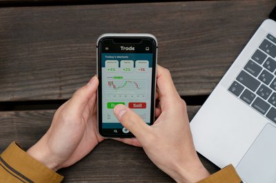 Person using mobile trading app to buy and sell stocks.